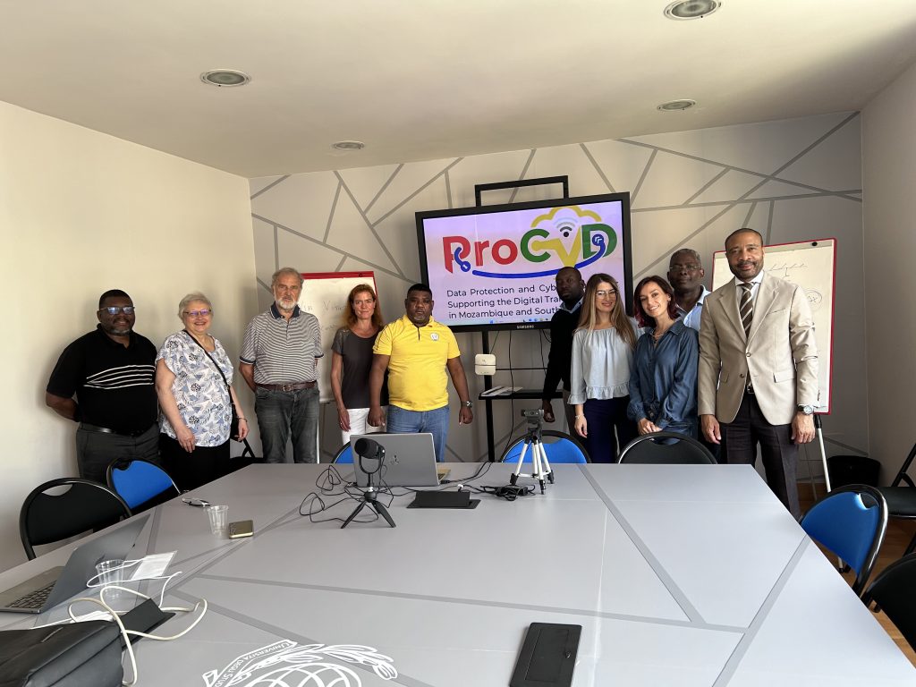 People standing in a University room in front of a screen showing the ProCyD Logo