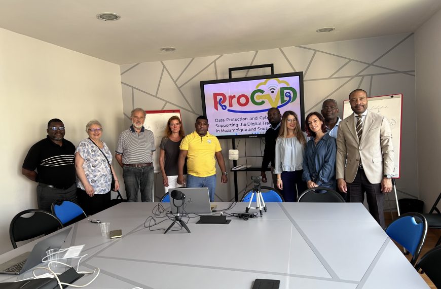 People standing in a University room in front of a screen showing the ProCyD Logo